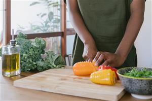 Woman chopping peppers for salad