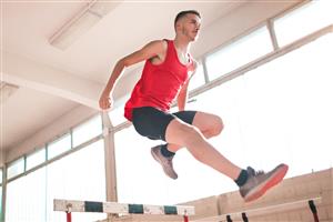 Man jumping indoor hurdle